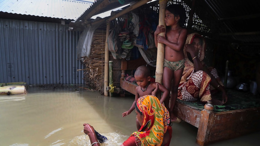flood affected villagers are seen inside their partially submerged houses