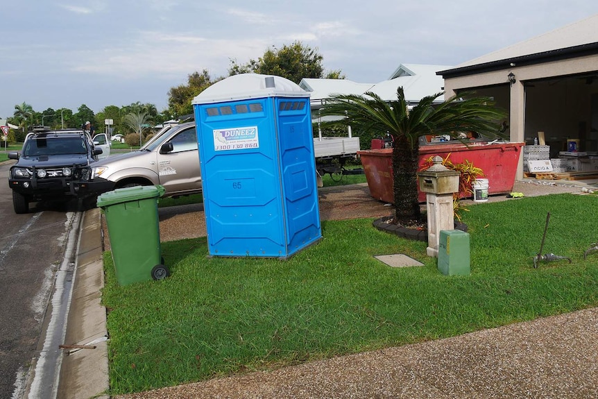 A skip bin and port-a-loo outside a home in the Townsville suburb Fairfield Waters where tradesmen are completing flood repairs