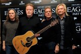 Four of the Eagles members with a signed guitar