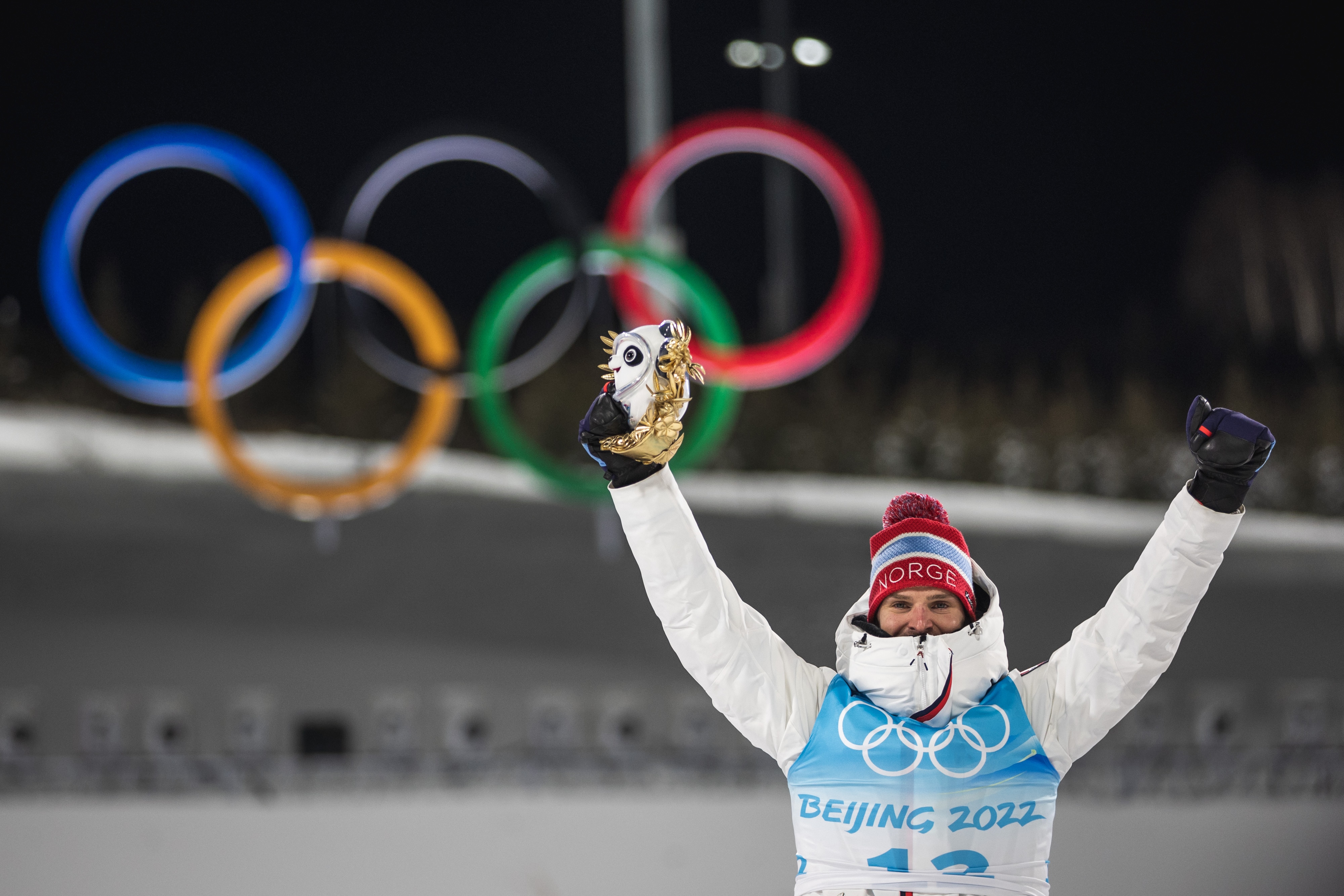 Joergen Graabak holds a panda toy in front of the Olympic rings