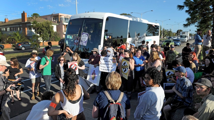 Protesters block a bus carrying Q society supporters
