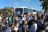 Protesters block a bus carrying Q society supporters