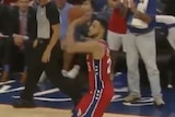 Screenshot of a video showing Simmons in the act of shooting outside the three-point arc.