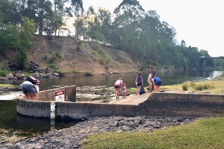 People paddling in the water at the weir.