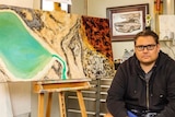 Rohin Kickett with one of his aerial landscape paintings
