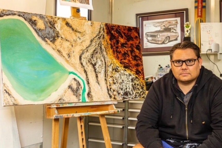 Rohin Kickett with one of his aerial landscape paintings
