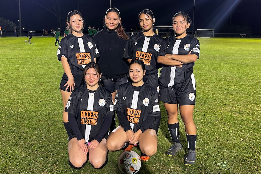 A group of young women of Asian descent on a soccer pitch. 
