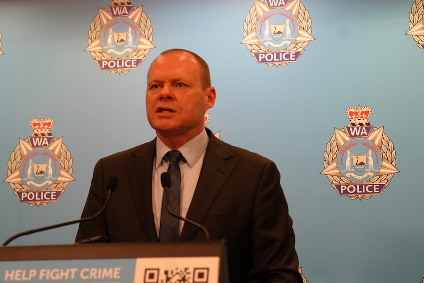 A WA Police detective named David Gorton speaks in front of WA Police banner.
