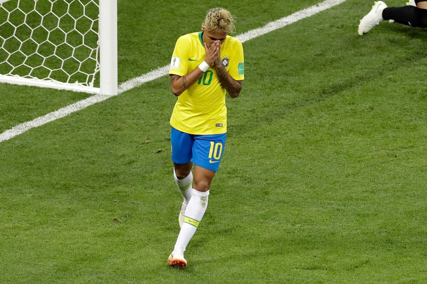 Brazil star Neymar holds his hands to his face.