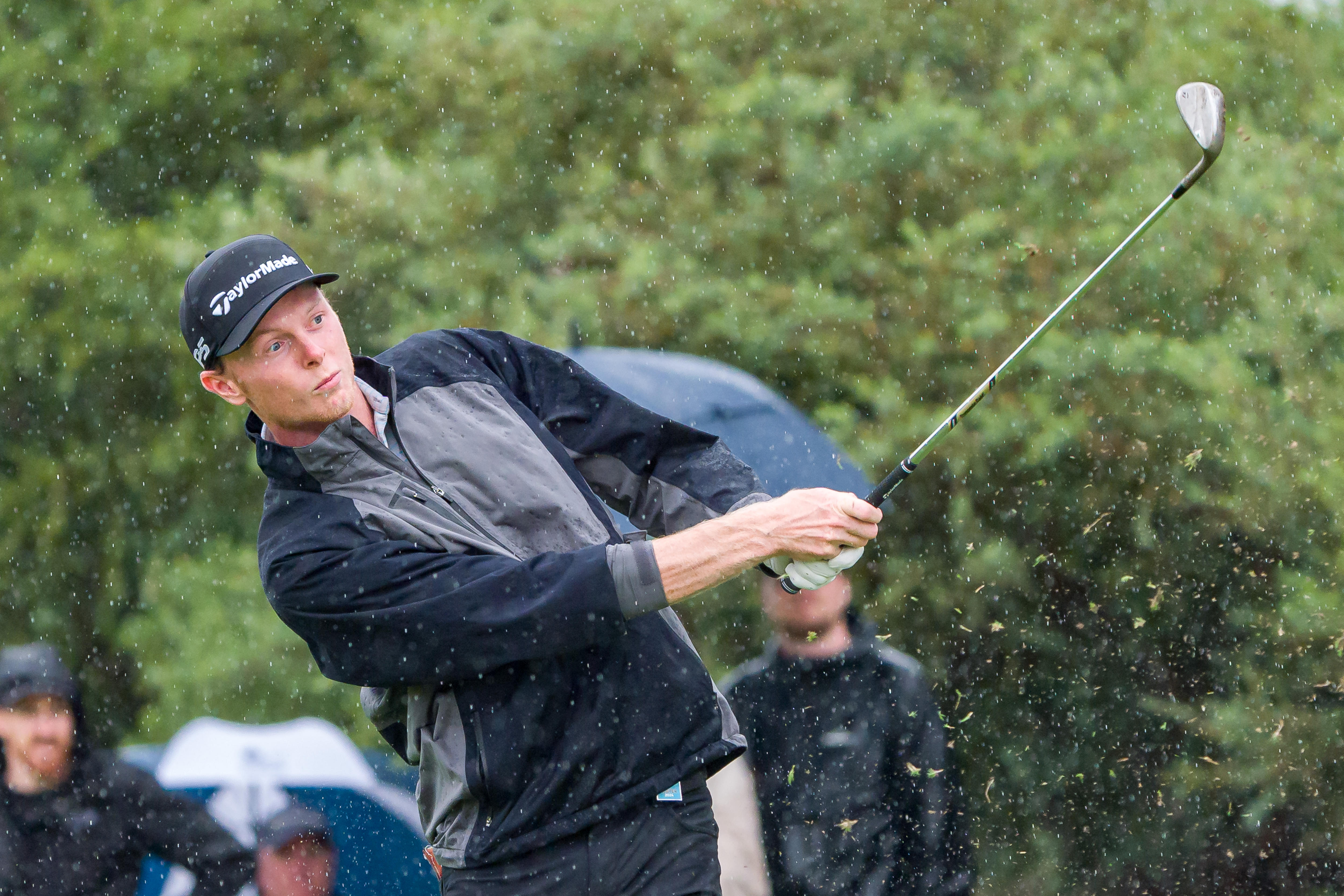 Ryggs Johnston plays a golf shot in the rain at the Australian Open.