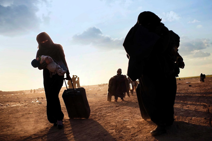 Women walking through the desert.