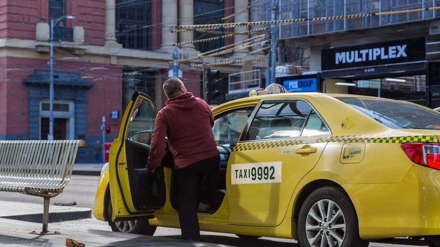 A man steps into a yellow cab in Melbourne's CBD.