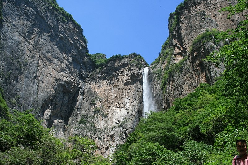 A semi-circle of large rocks with a waterfall in the middle of it.