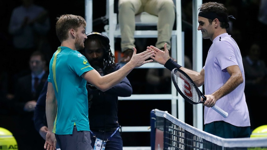 Belgium's David Goffin (L) shakes hands with Roger Federer after winning ATP World Tour Finals semi.
