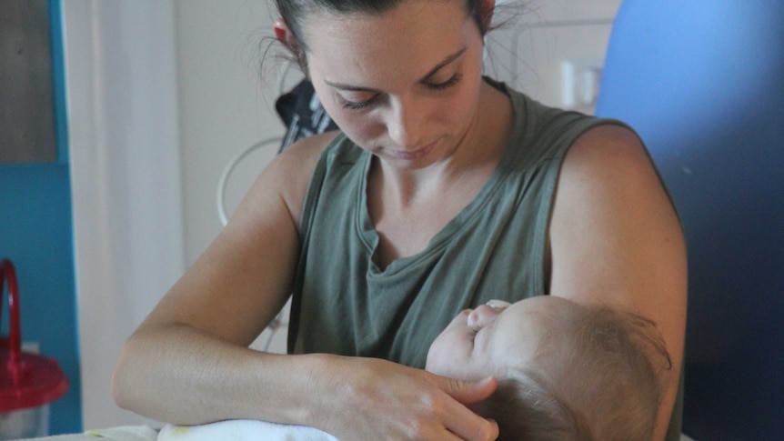 Chelsea Cocking sits with daughter Tahlea who is battling meningococcal disease in Perth Children's Hospital.