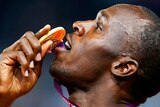 Usain Bolt poses with his gold medal on the podium after doing the double again.