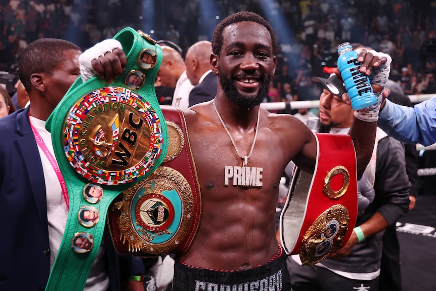 Terence Crawford celebrates with his championship belts
