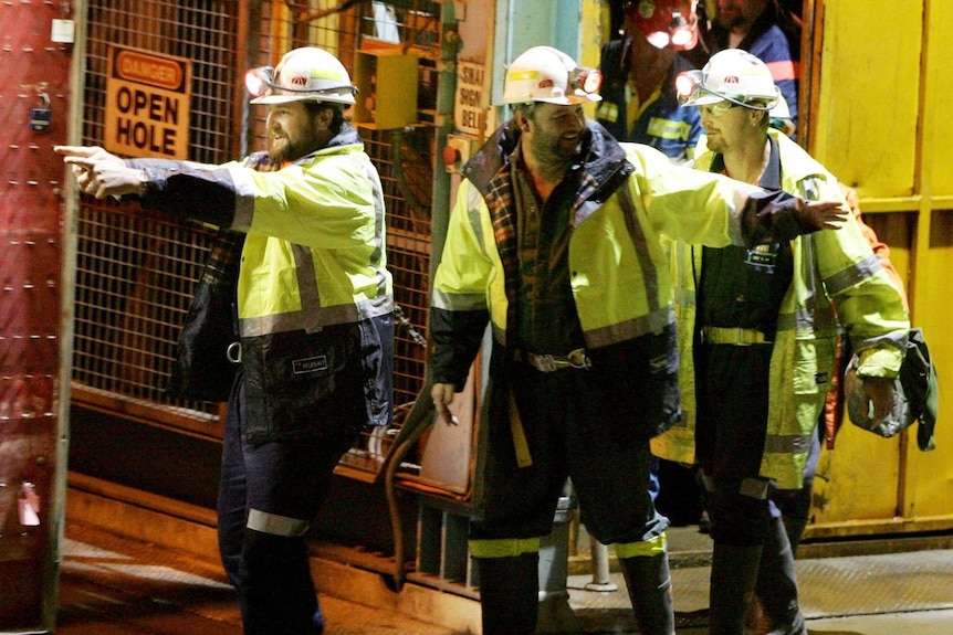 LtoR Todd Russell and Brant Webb wave as they emerge from the mine lift
