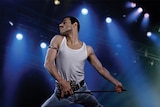 Colour still of Rami Malek as Freddie Mercury performing on stage in 2018 film Bohemian Rhapsody.