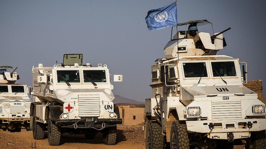 Three heavily armoured vehicles with the UN flag travel through Mali