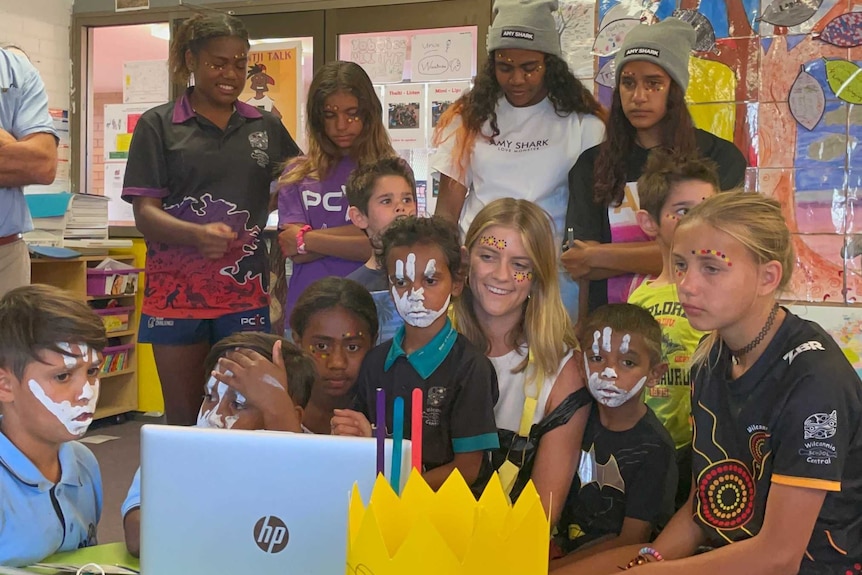 Sarah Donnelley and her students surrounding a laptop while they are live on air via Zoom call for the 2020 Aria Awards pre-show