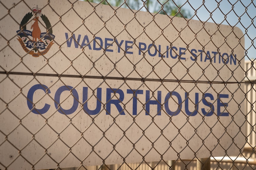 The sign of the Wadeye Courthouse is seen through a wire fence.
