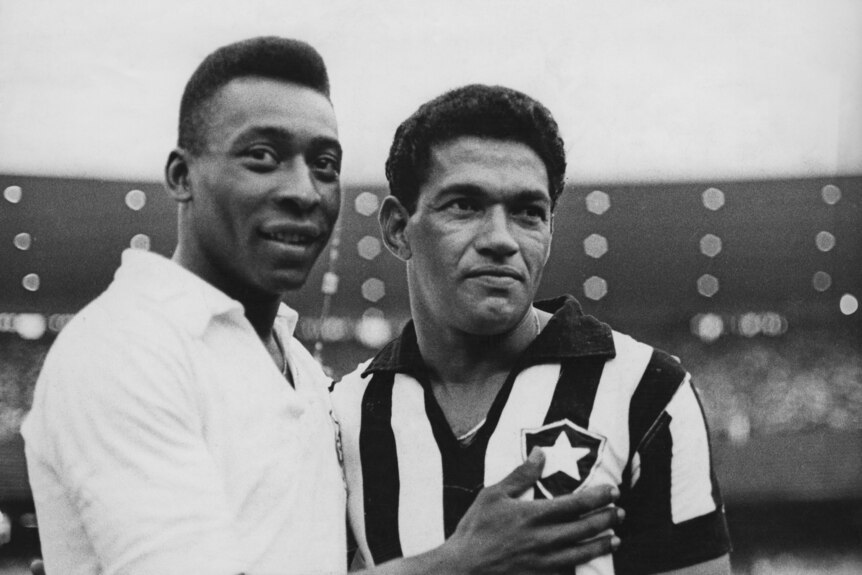 Pele pats Garrincha on the chest as both look off to the distance