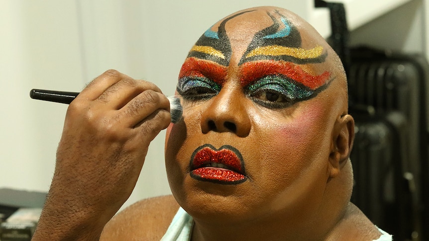 Man putting bright makeup on