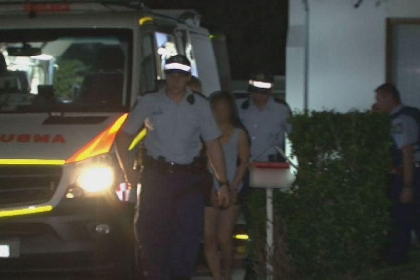 A handcuffed woman is led from a Riverwood home by police after a stabbing.