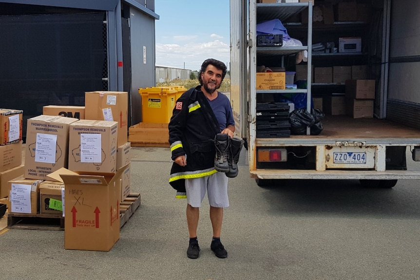 A man standing in front of a moving truck filled with boxes