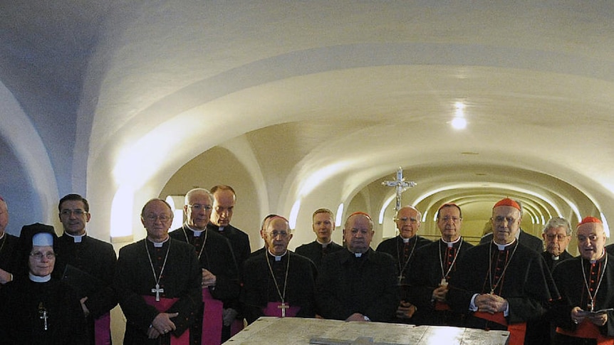 Members of the Vatican pray at the coffin of late pope John Paul II