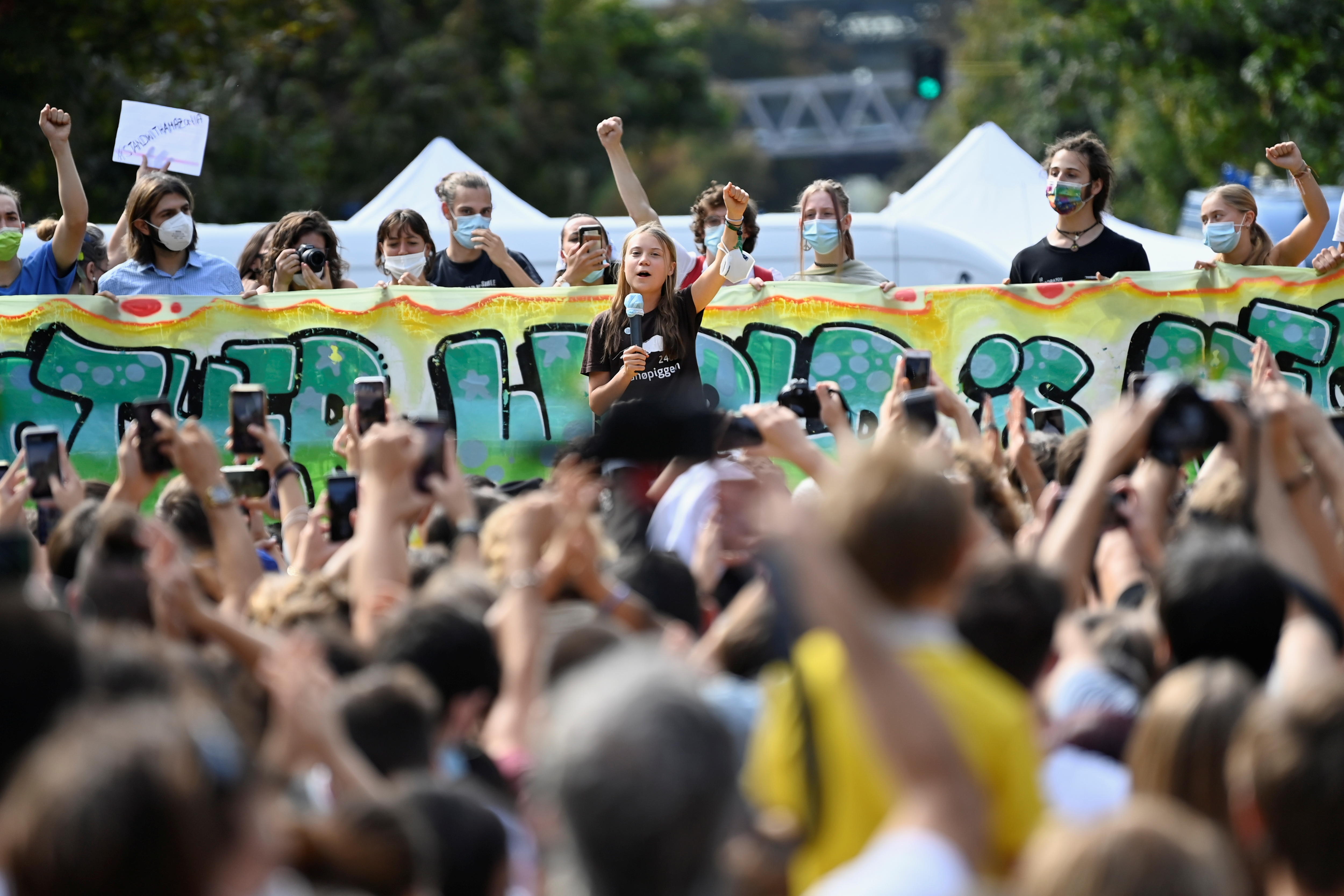 Greta Thunberg speaking to a crowd at a rally.