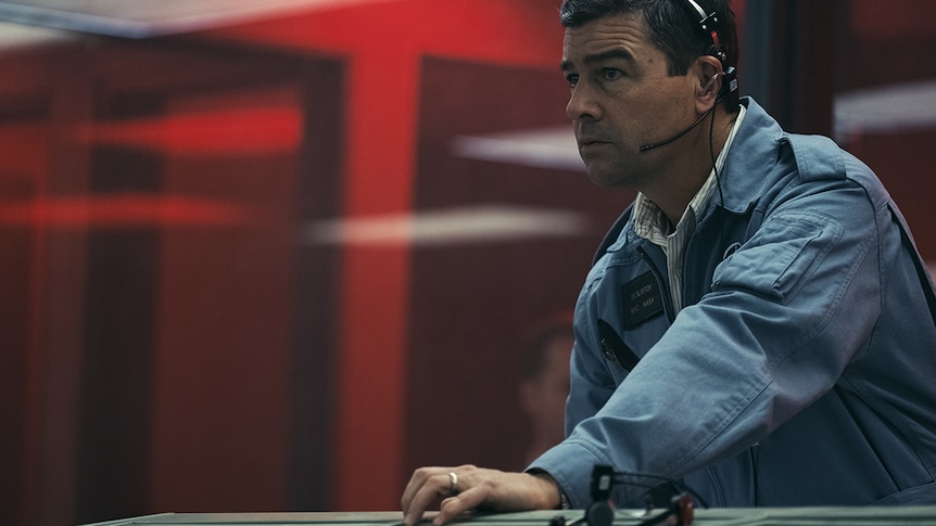 Still of Kyle Chandler as Deke Slayton sitting in the mission control set in 2018 film First Man.