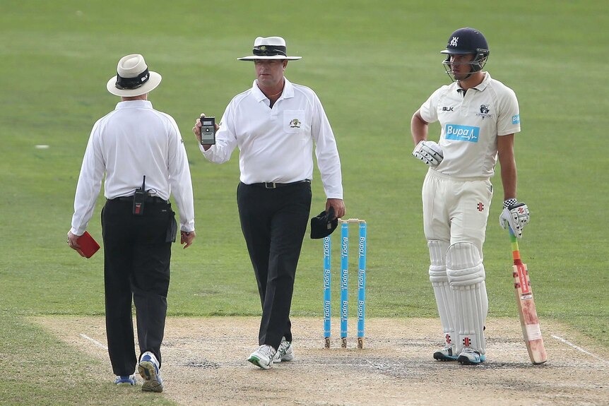 Umpires take a light reading on day three of the Sheffield Shield final