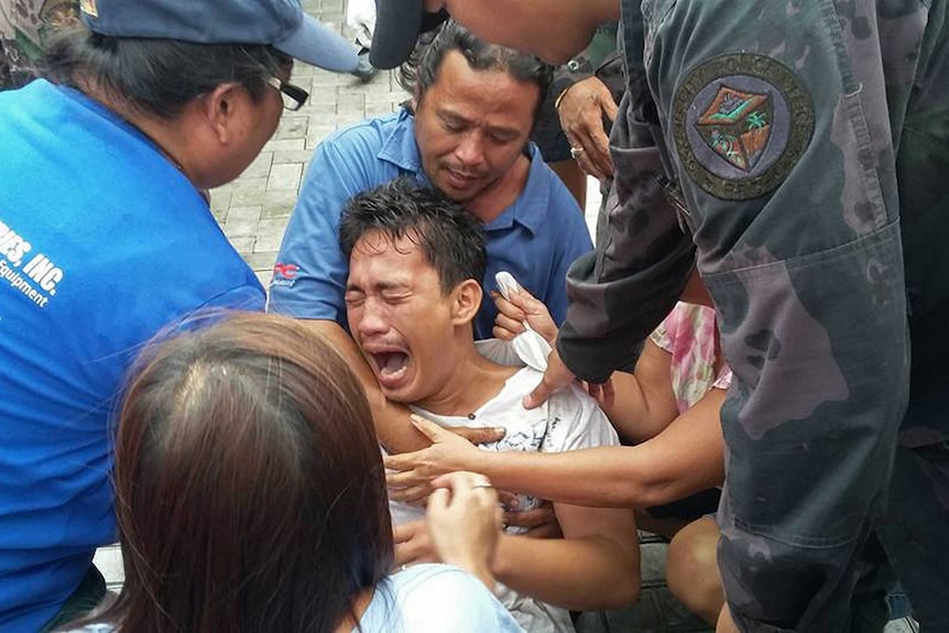 A survivor of a capsized passenger ferry cries