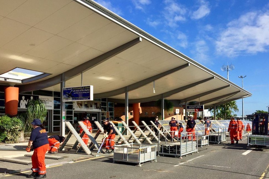 The SES erect a flooding barricade outside the airport terminal in Rockhampton.