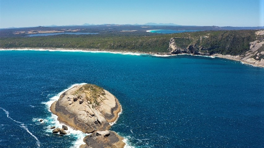 A drone shot of an island near the coastline.