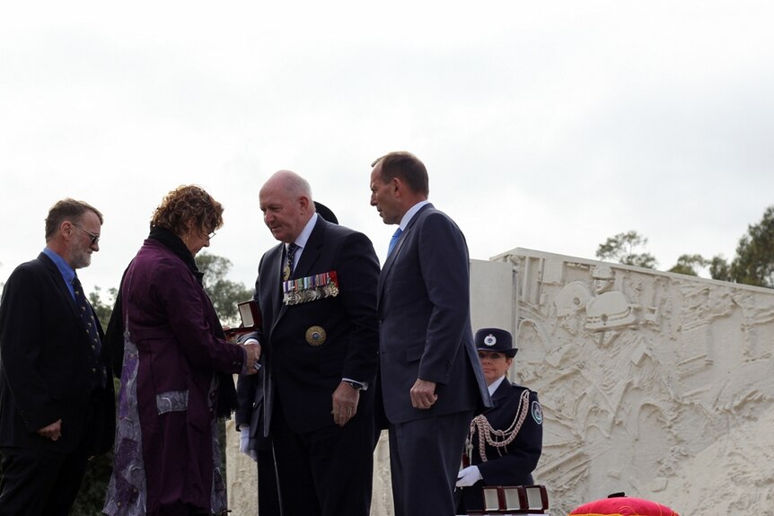 Genevieve and Jeffrey Howard meet Governor-General Peter Cosgrove and Prime Minister Tony Abbott, to receive a memorial medallion for their son Daniel, who was killed fighting fires in Cobar, NSW in 2014.