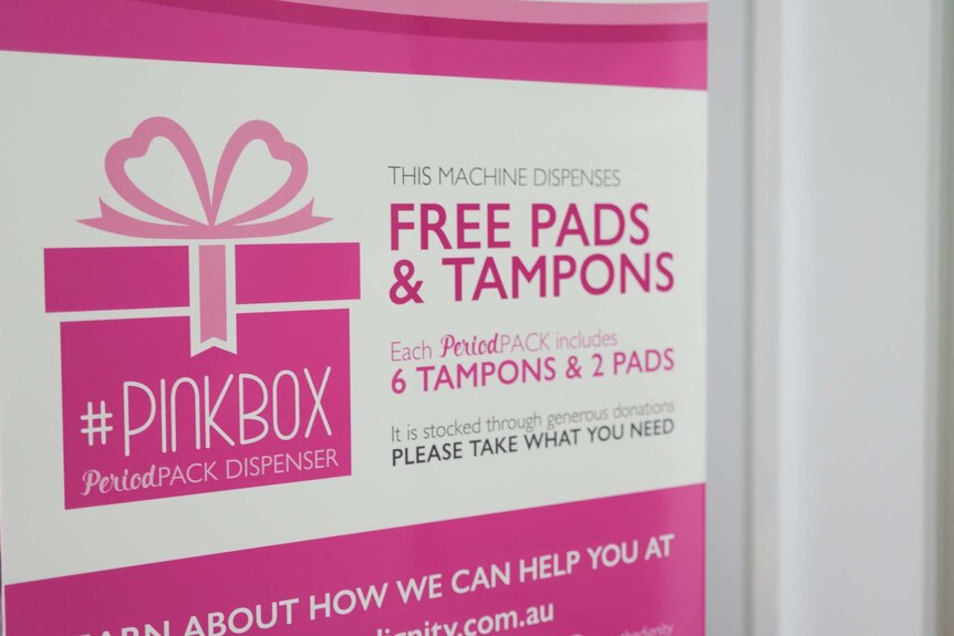 A photo of a pink and white sign which describes free sanitary items.