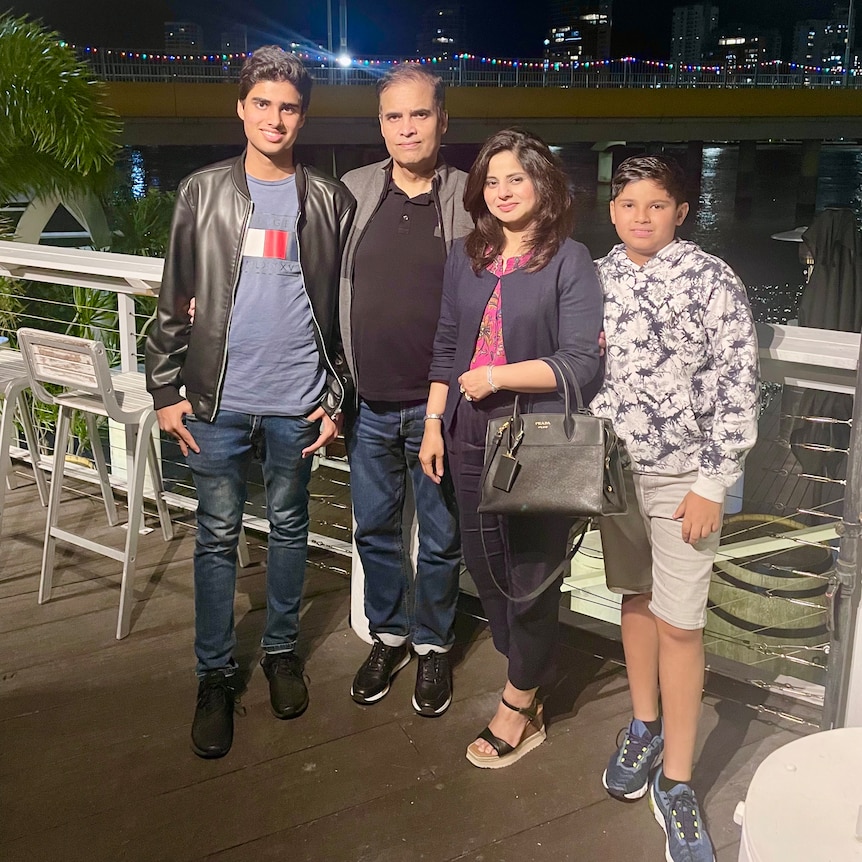 The Hussain family stand together on a balcony