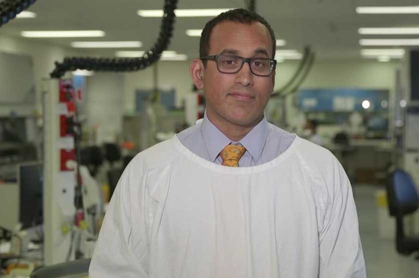 A man wears a surgical gown in a hospital.