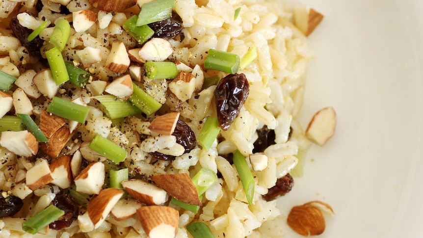 Close up of brown rice salad with nuts.