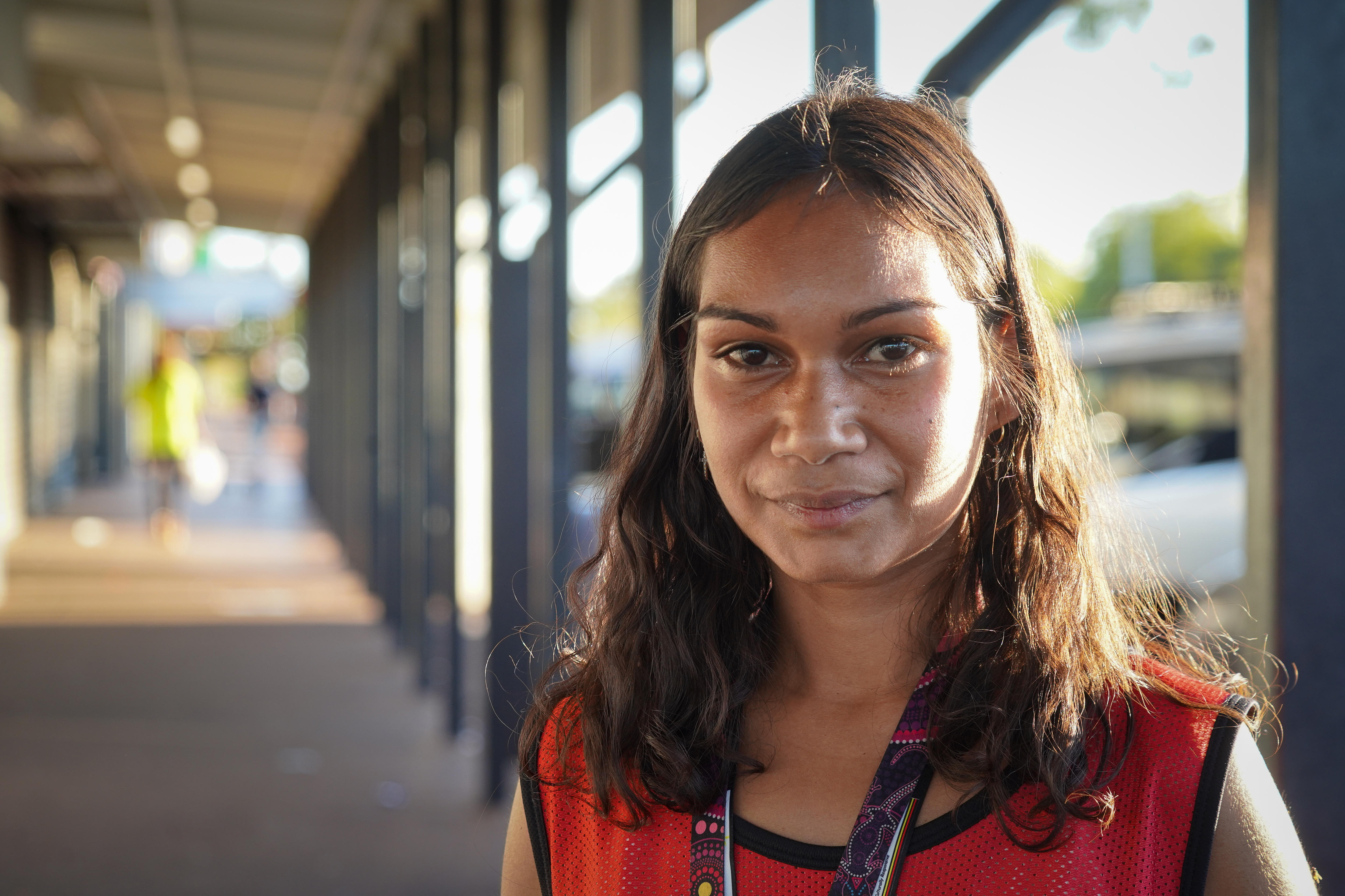 A young Aboriginal woman stands on the street