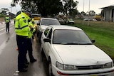 An officer issues a ticket to a female motorist during a random police check.