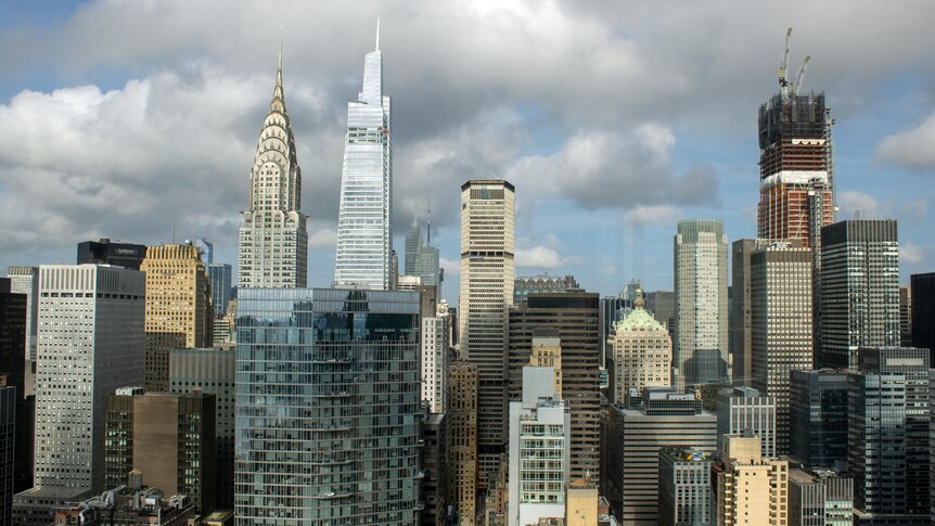 Skyscrapers are seen against a cloudy sky.