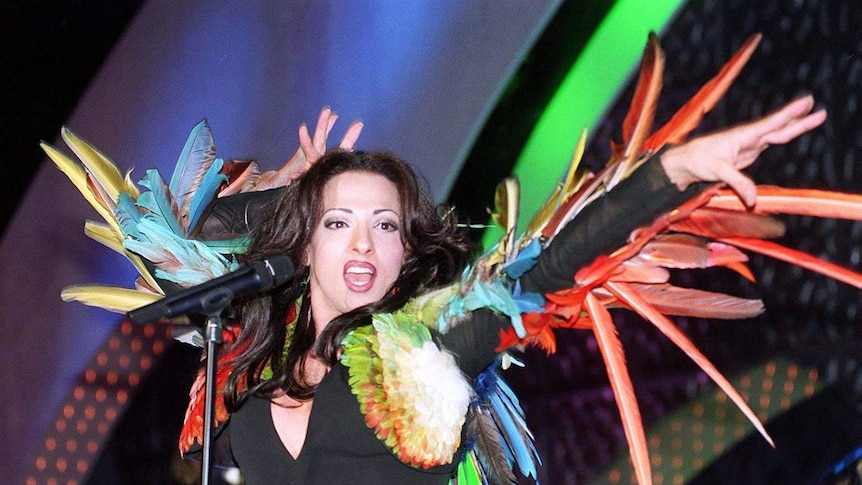 Dana International holds a microphone during her performance