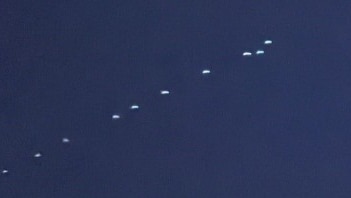 A photo of dozens of lights in a row across the night sky.