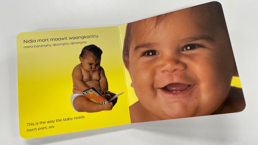 A close up of the pages of the translated Baby Ways book with portraits of a baby smiling and reading