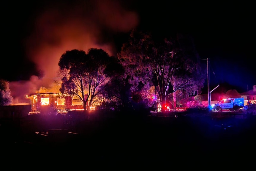 A house burning down at night.