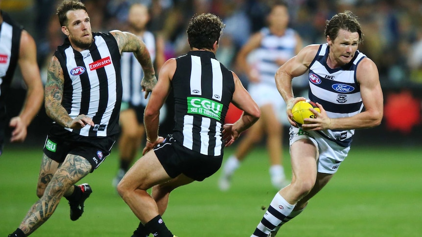 Geelong's Patrick Dangerfield (R) runs away from Collingwood's Dane Swan (C) and Jarryd Blair.